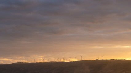 Obraz premium Find the support type and plan that works best for your needs, wind turbines on a green field with clouds and blue sky and a mountain range in the distance, north of waterton- alberta