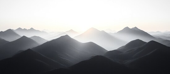 Majestic Misty Mountain Landscape with Dramatic Moody Atmosphere at Dawn or Dusk  Silhouetted mountain peaks rising above the fog and haze