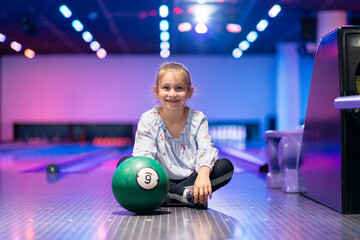 happy young girl having fun cheering while playing bowling game bowling alley