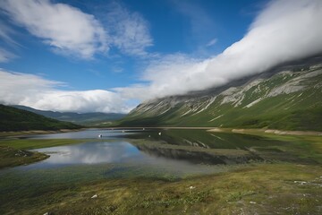 A tranquil lake nestled in a valley, reflecting the mountains and clouds. Green hillsides and a few boats are visible. The scene is peaceful and idyllic.