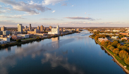 Fototapeta premium Aerial view of peaceful river through cityscape at sunset, urban tranquility