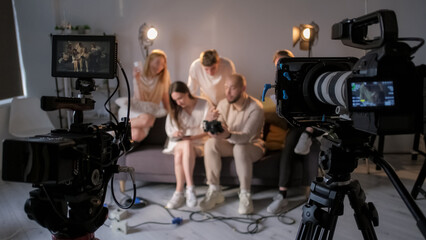 Backstage studio. Team communicate. Group people compares shooting results with planned project....