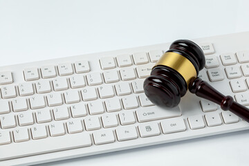 Gavel and keyboard isolated on white background. Online auction, cybersecurity and internet regulation concept.
