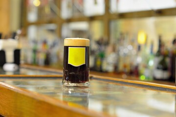 View on glass of beer on wooden bar counter, copy and brand space