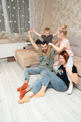 Family moments like smiling parents with children sitting on floor