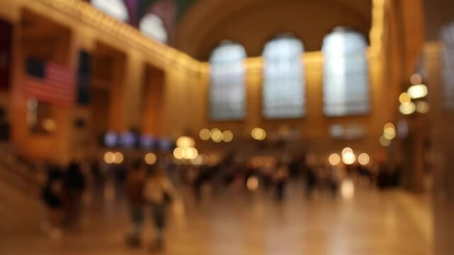 passengers at grand train station moving walking out of focus unrecognizable people and lights commute commuters