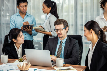 Diverse of business people from various ethnic group working in modern office environment. Productive and multi ethnic office workers engage in discussion for strategic business marketing. Meticulous