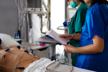 nurses performing electrocardiogram on a patient in ICU