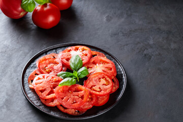 Red Tomato Slices and Basil Leaves on Black Plate, Mediterranean Cuisine