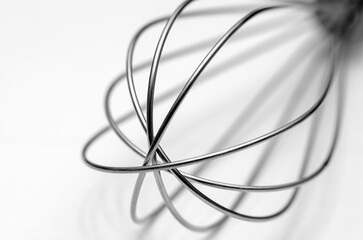 Minimalistic abstract of a wire whisk on a white background