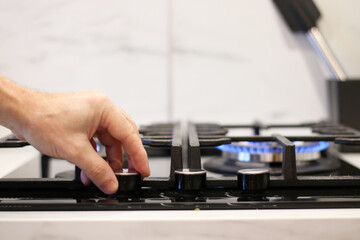 A cook lights a gas stove to cook food.