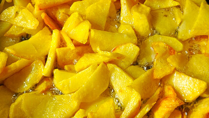 Tasty crispy fried wedges of potato with fresh rosemary served in an old metal skillet in a close