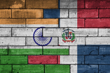 colourful painted big flag of india and flag of dominican republic on a massive old brick wall background. concept