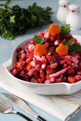 Salad Vinaigrette with beets, potatoes, carrots, squid, pickles and vegetable oil on blue background