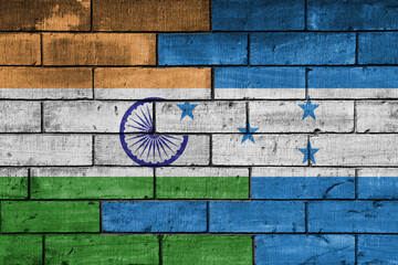 colourful painted big flag of india and flag of honduras on a massive old brick wall background....