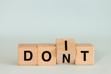 Don't do and do it. Conceptual words, don't do changing do it. Words on wooden blocks. copy space.