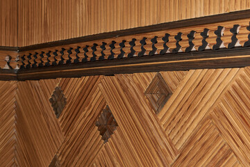 I decorated the hallway with wood in my apartment in 1990. A fragment of the wall decoration with wooden slats with a three-dimensional geometric pattern and natural wood texture in warm colors.