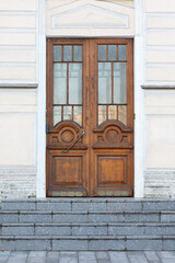 Old wooden door with glass on the steps. Outside.
