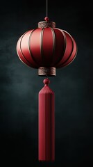 Fototapeta premium A single red lantern hanging against a dark background, showcasing a minimalist aesthetic.