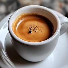 A close-up of a freshly brewed espresso with a rich golden crema, served in a white porcelain cup on a matching saucer
