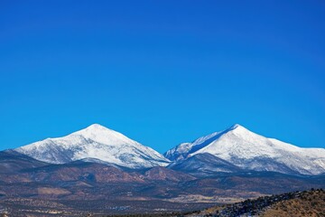 Fototapeta premium A serene winter landscape with snowy mountains in the background, perfect for use in travel or nature-related projects