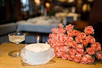 Sweet celebration with a candlelit cake and fresh roses in an elegant setting