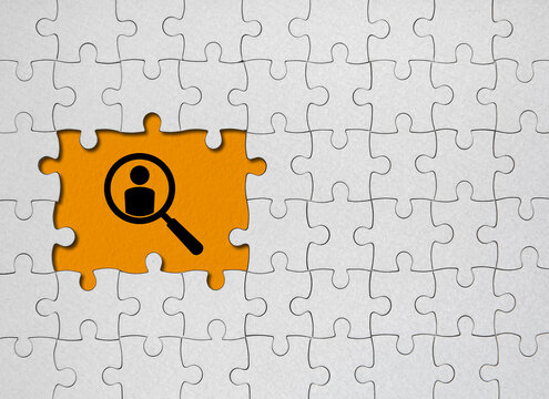 We are hiring concept. White jigsaw puzzle with word and orange background