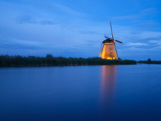 Old windmills in the Netherlands. Reflections on the water surface. Dutch canals. Reflections on the surface of the water. Photo for background, wallpaper, postcards.