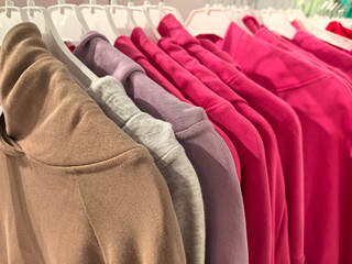 Colorful collection of casual wear hangs in modern boutique display