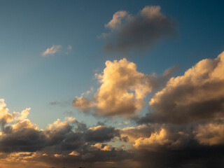 Dark dramatic sunset sky with clouds and sun beams and flare. Nature background for design and sky replacement.