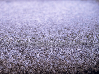 Frozen ice on a metal surface of a car hood. Cold winter season concept. Selective focus.