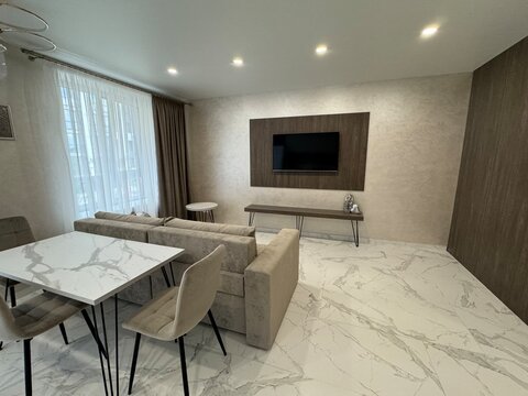 Modern minimalist living and dining area with marble accents and stylish lighting design - Powered by Adobe