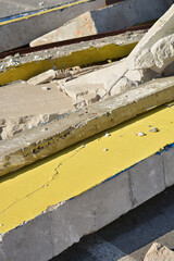 A pile of broken concrete slabs, some painted yellow - debris from demolition site