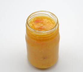 Home made orange marmalade in a transparent glass jar.