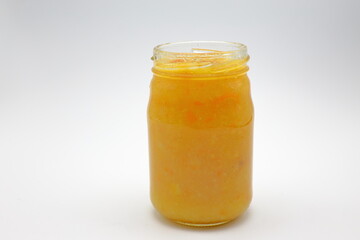 Home made orange marmalade in a transparent glass jar.