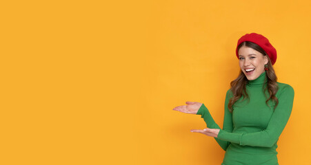 Happy and positive young woman in red beret on isolated orange background.