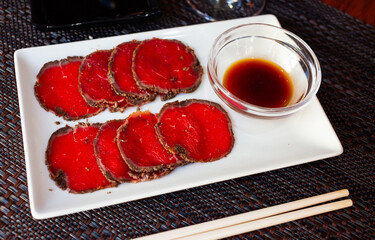 Traditional Japanese dish Gyusashi - thin slices of raw beef with sweet soy sauce