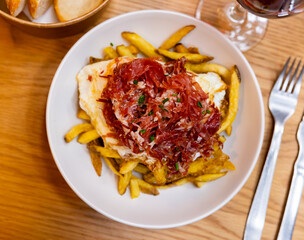 Tasty scrambled eggs with ham potatoes and spices for breakfast