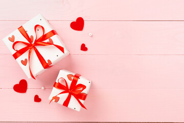 Gift boxes with red hearts on wooden background, top view