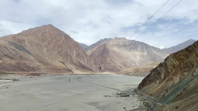 View of beautiful Himalayan mountains and sand dunes at Khalsar with the longest high-altitude zipline in Nubra Valley in the Himalayas. Ladakh, India.