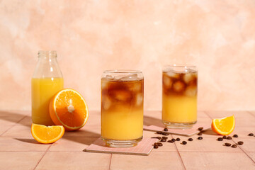 Glasses of tasty orange espresso on table