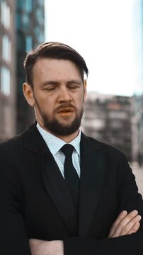 4K. UHD. Portrait of Young successful beard businessman in suit and tie disgusted with Your opinion. He looks mistrust with crossed hands. Head denial. Sunny morning teal and orange middle shot