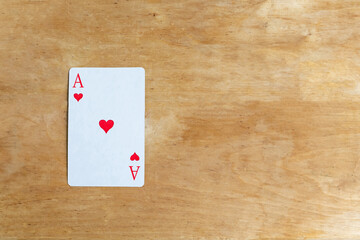 Ace of Hearts playing card on wooden background, top view, copy space