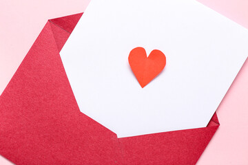 Composition with envelope, card and paper heart on pink background. Valentine's Day celebration