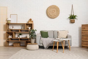 Interior of living room with comfortable sofas, chest of drawers and shelving unit