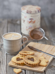 Still life of homemade heart-shaped cookies along with a coffee and kitchen utensils. Romantic snack