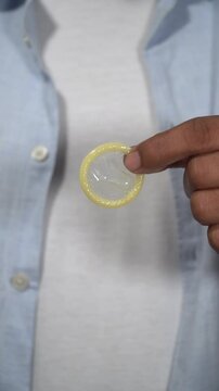 Doctor showing condom removing from wrapper