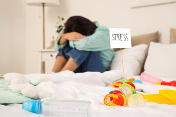 Sad woman suffering from postnatal depression in bedroom
