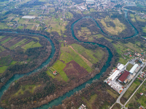  Aerial view of winding blue Zeta river in autumn valley near Danilovgrad, scenic river meander in evening light, Montenegro.
