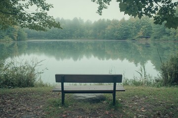 Obraz premium Calm lakeside view with bench surrounded by trees in a peaceful natural setting